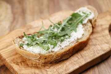arugula on rustic bread with ricotta cheese