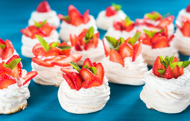 A small meringue Pavlova dessert with some strawberry slices
