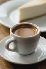fresh espresso and cheesecake on table