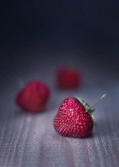 red fresh strawberries on wooden dark background, rustic style, toned, close up