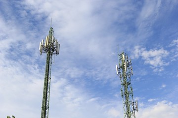 Two communications tower with blue sky.