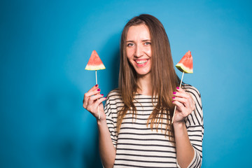Fototapeta na wymiar Summer, vacation, diet and vegans concept - Beautiful smiling young woman holding watermelon slice on stick