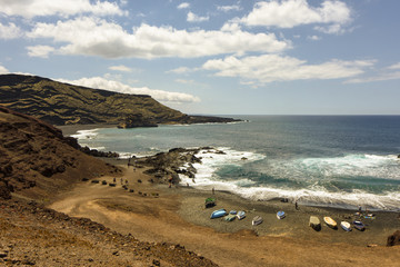 Fototapeta na wymiar Beach with boats and tourists at El Golfo next to the Green Lagoon, Lanzarote, Canary Islands, Spain, Europe