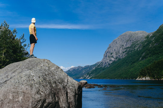 A lonely guy stands on a stone in norway
