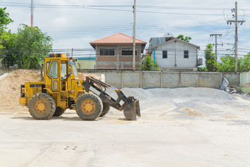 Fototapeta na wymiar Yellow Hydraulic Tractor Loader or Backhoe earthmover woking in Construction site