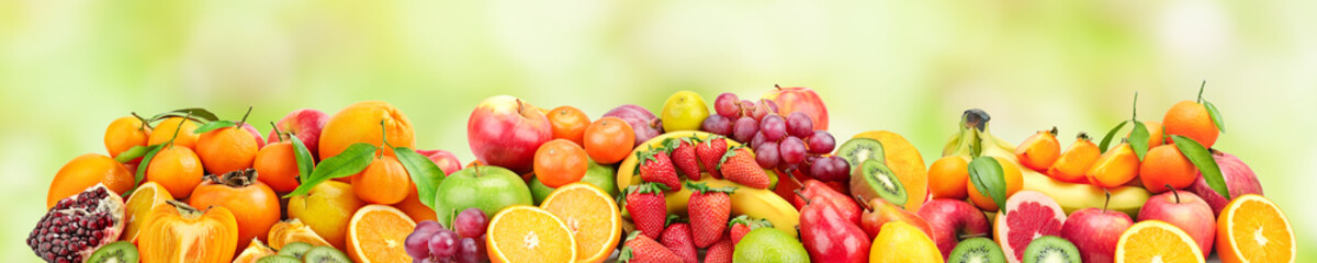 Panoramic wide photo of fresh fruits for skinali on a green background.