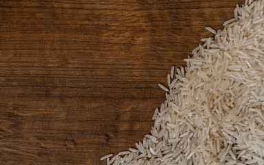 White long uncooked rice basmati on wooden table with copy space. top view