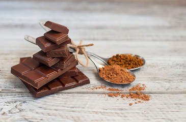 Chocolate, cocoa and nuts on a light, wooden background. Close-up with place for text