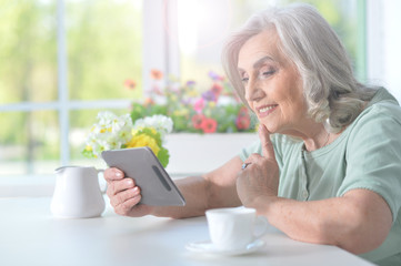 Beautiful old woman with a tablet