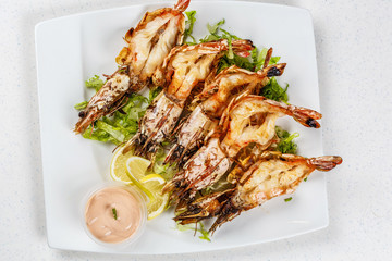 Grilled tiger prawns served with leafs and lemon