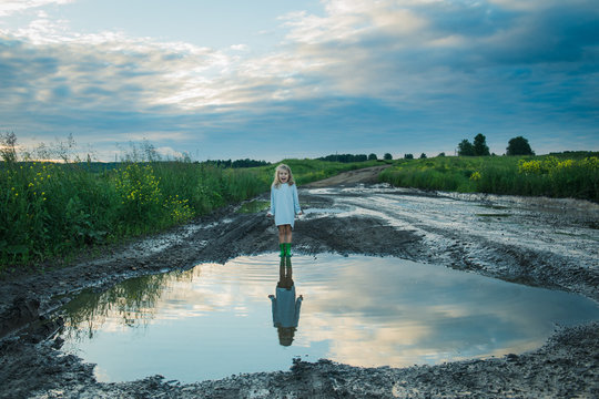 little girl big puddle country road