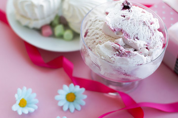 berry ice cream in glass dessert bowl on blurred background with gifts, sweets, pink background, selective focus, blur