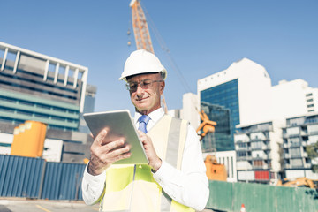 Construction manager controlling building site and tablet device