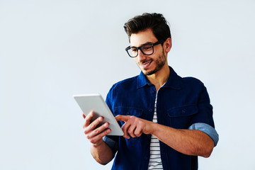 Young casually dressed man browsing on tablet