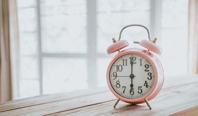 Clock on wood in the morning, blurred living room background.