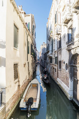 Fototapeta na wymiar Venice, Veneto, Italy. May 21, 2017: Narrow canal in the oldest part of the city, with a gondola strolling