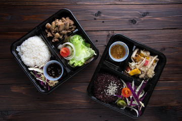 Freshly served bento box  on wooden table background. top view