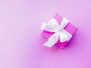 gift box with pink ribbon on pink background