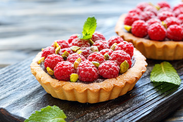 Mini tarts with chocolate, raspberry and pistachio. - obrazy, fototapety, plakaty