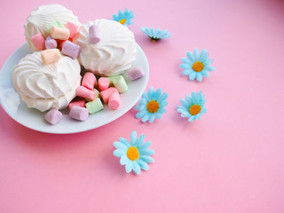 Marshmallow in white plate on pink background