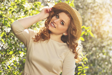 Funky beauty. Portrait of young beautiful woman in dress adjusting her hat and smiling while...