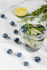 Summer refreshment diet drinks. Infused detox waters in different glasses nd bottles with rosemary,...