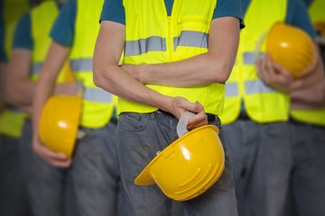 Many workers in vest with protective helmet. - obrazy, fototapety, plakaty