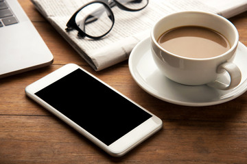 mobile phone with office supplies and cup of coffee