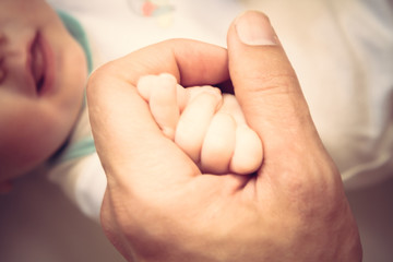 Parent holding his newborn baby hand symbolizing love and care