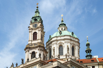 Fototapeta na wymiar View of tower and dome of Church of Saint Nicholas (St. Nicholas Church) in Mala Strana or Lesser Town in Prague, Czech Republic, in the daytime.