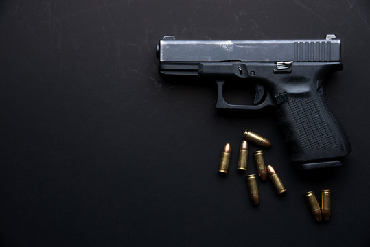 Gun with ammunition on dark table background. 