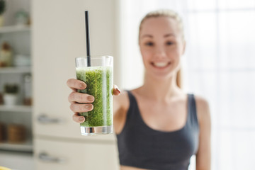 Young woman making detox smoothie at home