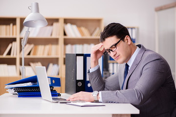 Naklejka premium Tired businessman working in the office
