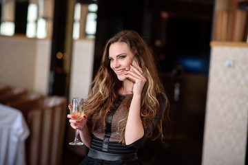 A beautiful girl in a restaurant communicates by phone.