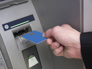 Man inserts the credit card into ATM