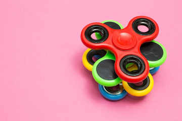 Fidget spinner stress relieving toy on the pink background.