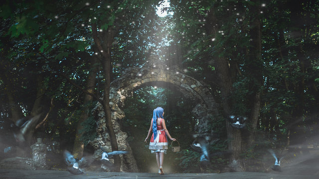 Beautiful young woman wearing elegant dress standing on a road in the forest with rays of sunlight beaming through the leaves of the trees. Format 16:9 (film frame).