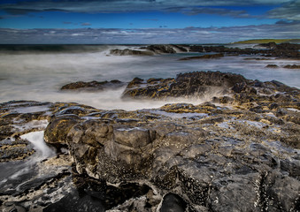 Long time exposure of waves around rocks at the Wild Coast at the Indian Ocean in South Africa