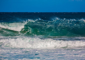 Fototapeta premium Breaking waves of the Indian Ocean at the Wild Coast of South Africa with cloudy sky