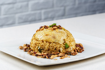 Traditional Middle Eastern fish and fried rice dish with fried pine nuts