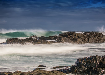 Long time exposure of waves around rocks at the Wild Coast at the Indian Ocean in South Africa