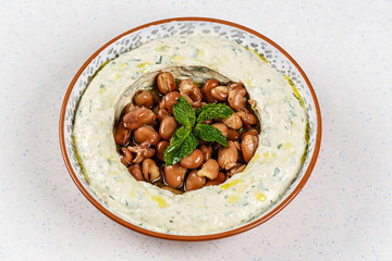 Arabic food Hummus with parsley in a traditional bowl.