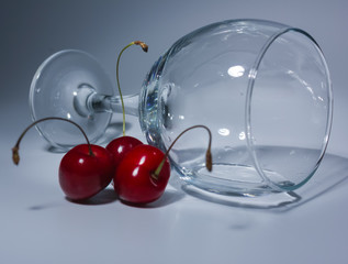 the composition of the glass of wine and cherries. Glass of lies, and next to it, berries cherries. closeup, white background glass with cherry and water.