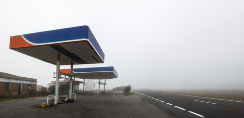 Panoramic view of Abandoned gas station in foggy day