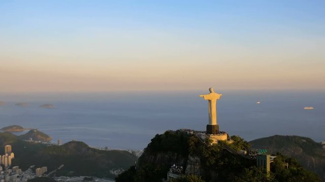 Aerial View Of Christ The Redeemer Statue and Botafogo Bay. Sunset warm light. Rio de Janeiro, Brazil