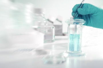 Scientific background image with slide glass in gloved hand