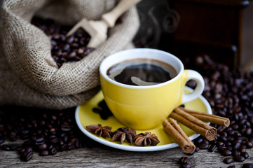 A cup of coffee and coffee beans on a wooden table