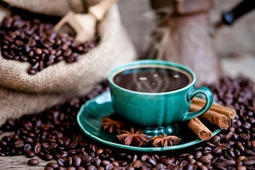 A cup of coffee and coffee beans on a wooden table