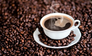 A cup of coffee and coffee beans on a wooden table