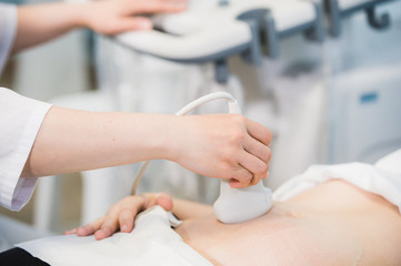 Close-up Of Doctor Moving Ultrasound Probe On Pregnant Woman's Stomach In Hospital